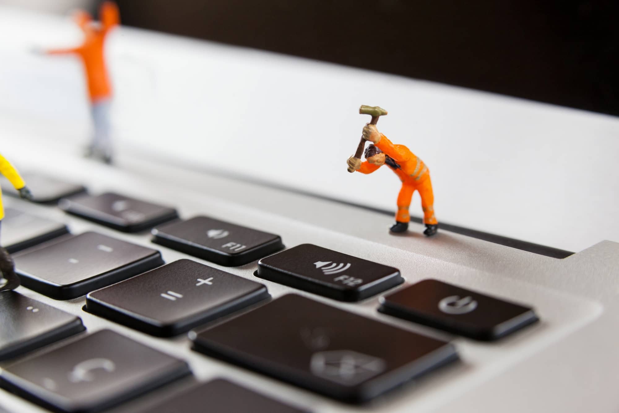 toy man hitting keyboard with hammer